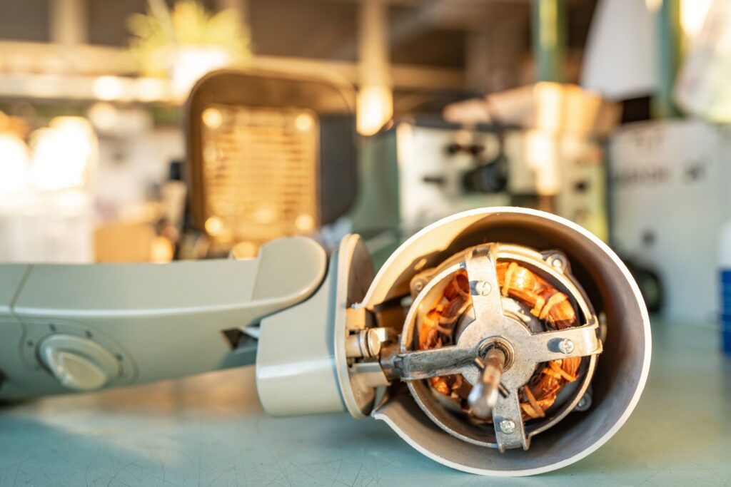 Close-up of iron motor from home cooling fan lies on a table