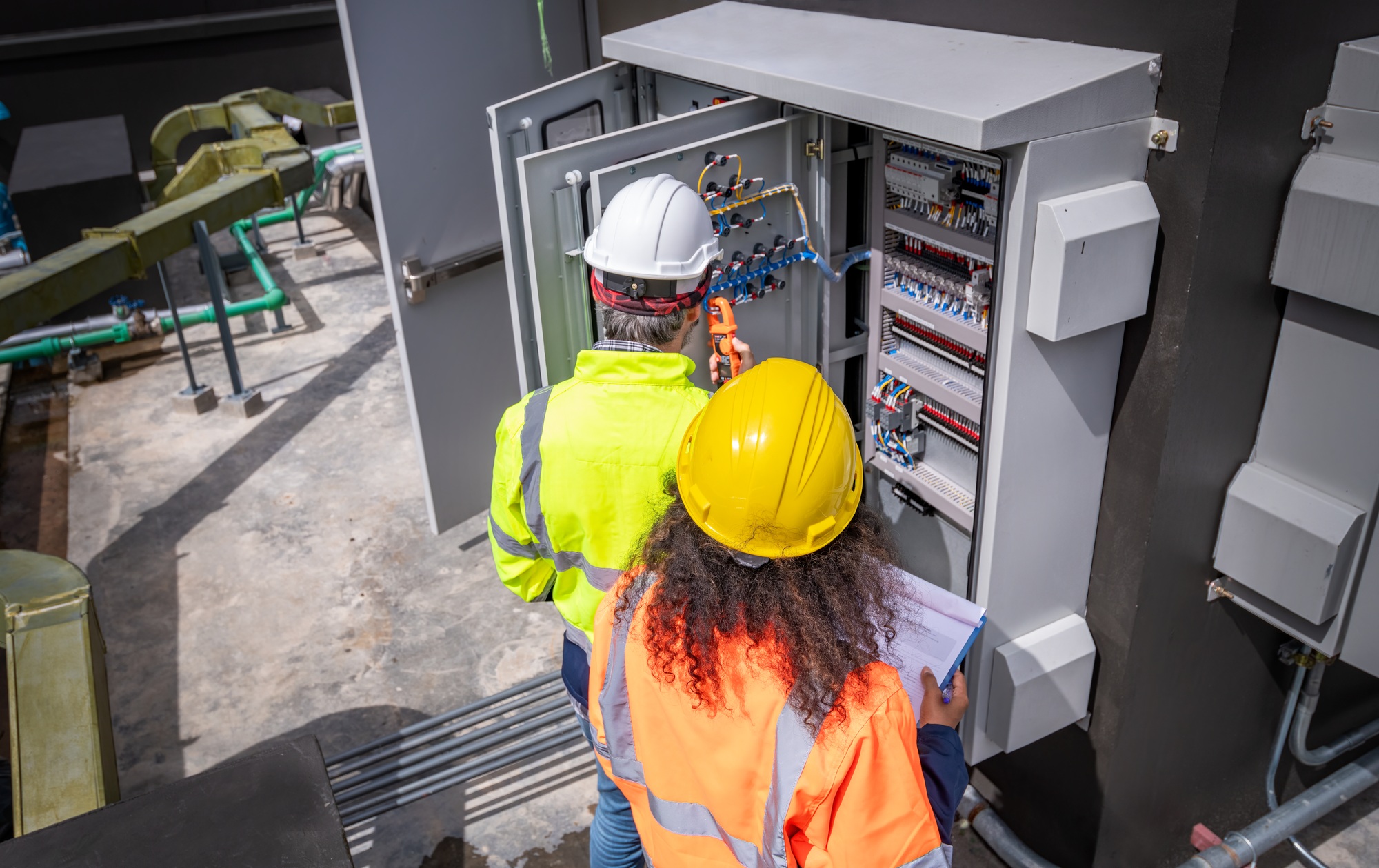 Engineer wearing safety uniform checking and inspecting at MDB panel working with electric switchboa
